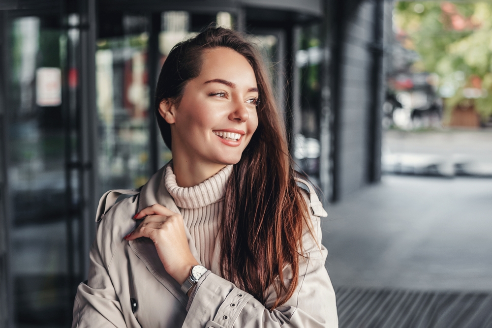 Smiling professional woman standing outside a contemporary building, reflecting confidence, approachability, and patient-centered care associated - sidiq aldabbagh md