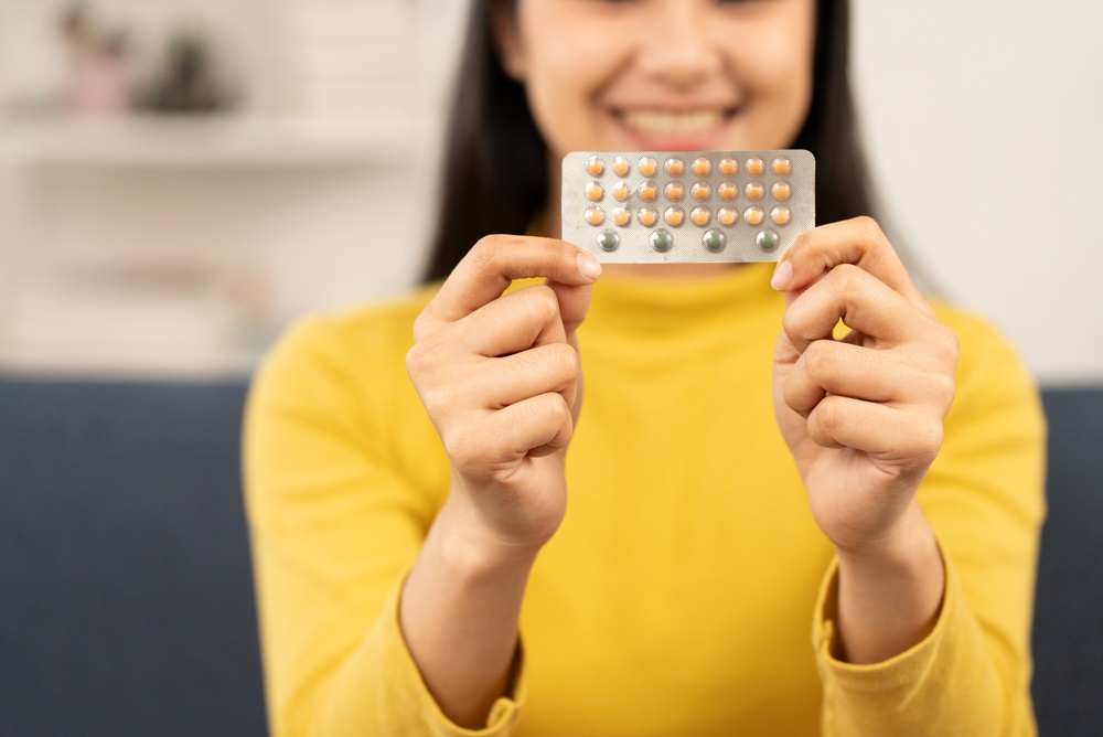 young woman holding birth control pill blister pack at home, contraception and reproductive health concept, daily oral contraceptive, women healthcare and self care. contraception, birth control,